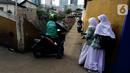 Pengendara sepeda motor melintasi jalur alternatif saat anak sekolah berjalan di belakang Kompleks Patra Jasa, Jakarta Selatan, Rabu (1/3/2023). (Liputan6.com/Johan Tallo)