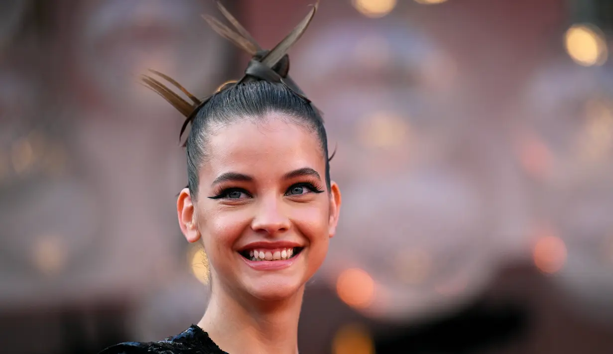 Barbara Palvin tersenyum saat tiba di pemutaran perdana film 'White Noise' dan upacara pembukaan Festival Film Venesia edisi ke-79 di Venesia, Italia, Rabu (31/8/2022). Terlepas dari apa yang dikatakan gravitasi, rambut Palvin tetap sempurna di setiap pose, menoleh, dan bahkan berciuman dengan Sprouse di karpet merah. (AFP/ TIZIANA FABI)