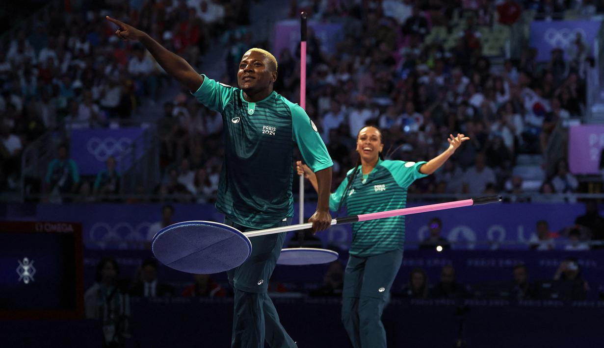 Dua orang volunteer mempersiapkan arena pertandingan perebutan medali perunggu taekwondo putri kelas -57kg Olimpiade Paris 2024 di Grand Palais, Paris, pada 8 Agustus 2024. (AFP/David Gray)