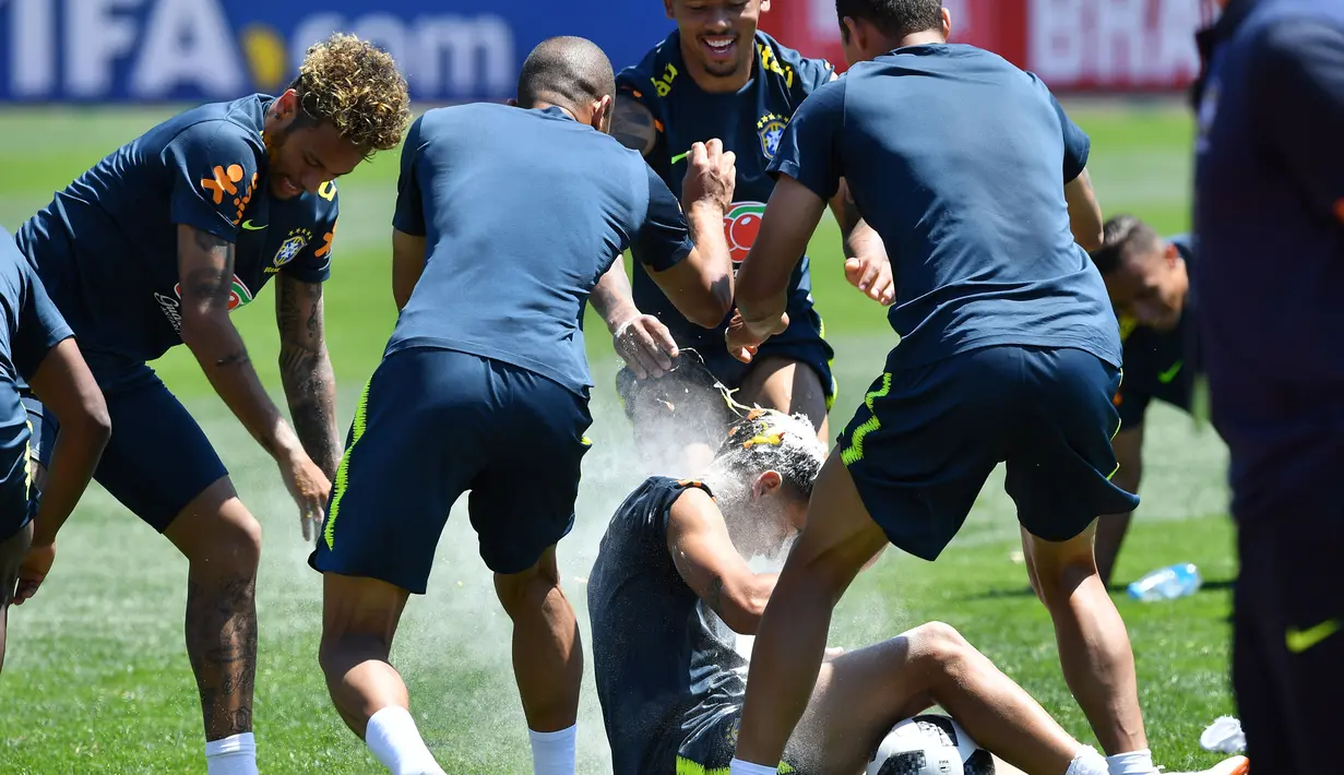 Suasana saat para pemain sepak bola Brasil melempar tepung dan telur ke kepala Philippe Coutinho dalam sesi latihan jelang Piala Dunia 2018 di Sochi, Rusia, Selasa (12/6). (Nelson Almeida/AFP)