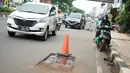 Kendaraan melintas di samping bekas galian proyek yang tidak tuntas pengerjaannya di Jalan Margonda Raya, Depok, Jawa Barat, Kamis (9/5/2019). Kondisi jalan yang diabaikan selama beberapa bulan terakhir tersebut memersempit dan mengganggu aktivitas warga. (Liputan6.com/Immanuel Antonius)