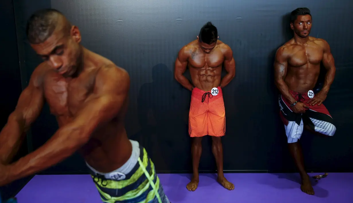 Peserta binaraga melakukan pemanasan di belakang panggung saat menunggu dimulainya kontes Arnold Klasik Eropa 2015 di Madrid, Spanyol, Jumat (25/9). (REUTERS/Susana Vera)