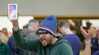 Shalin Mobi, dari India, berteriak setelah menjadi orang pertama yang membeli iPhone X di toko Apple Union Square di San Francisco (3/11). (AP Photo / Eric Risberg)