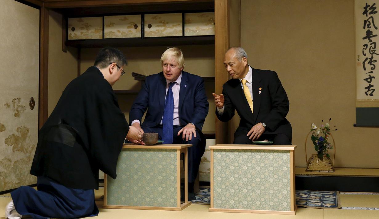 Walikota London Boris Johnson (tengah) dan Gubernur Tokyo Yoichi Masuzoe (kanan) ditawarkan secangkir teh dalam upacara minum teh, Tokyo, Rabu (14/10/2015). Johnson di jepang untuk menjalin kerja sama di bidang perdagangan dan budaya. (REUTERS/Issei Kato)