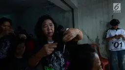 Warga RW 1 Koja, Jakarta Utara, menikmati potong rambut gratis, Jakarta, Sabtu (1/12). Kegiatan tersebut diselenggarakan Sahabat Indonesia Maju (SIMA) dan sebagai bentuk bakti sosial kepada masyarakat. (Merdeka.com/Imam Buhori)