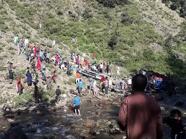 Tim penyelamat dibantu warga mengevakuasi korban kecelakaan bus di di wilayah Kishtwar di negara bagian Jammu dan Kashmir (1/7/2019). Sekitar 35 orang tewas dan 22 orang terluka akibat bus sarat penumpang tersebut terjun ke jurang. (AFP Photo/STR)