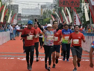 Pelari tiba di garis finish saat mengikuti Semarang 10K di Kota Semarang, Jawa Tengah, Minggu (16/12). Sebanyak 2.000 pelari mengikuti Semarang 10K. (Liputan6.com/Gholib)