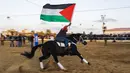Aksi pria Palestina saat menunggangi kudanya selama mengikuti Arabian Horse Show di Kota Gaza, Palestina (3/3). Ajang yang digelar di Gaza ini sebagai unjuk kebolehan warga Gaza yang ahli mengendalikan dan menjinakkan kuda. (AFP Photo / Mohammed Abed)