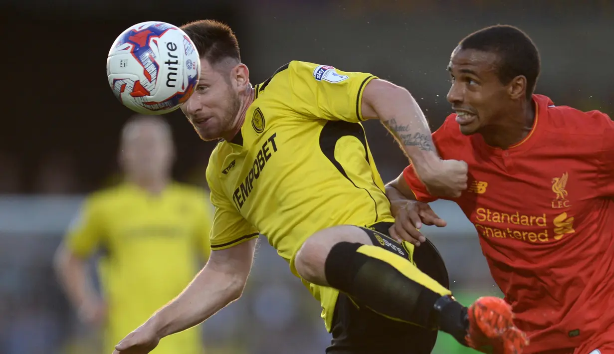 Pemain Burton Albion, Calum Butcher (kiri) menghadang pemain Liverpool, Joel Matip pada putaran kedua piala Liga Inggris di Pirelli Stadium, Burton-on-Trent, (24/8/2016) dini hari WIB.  (AFP/Oli Scarf)
