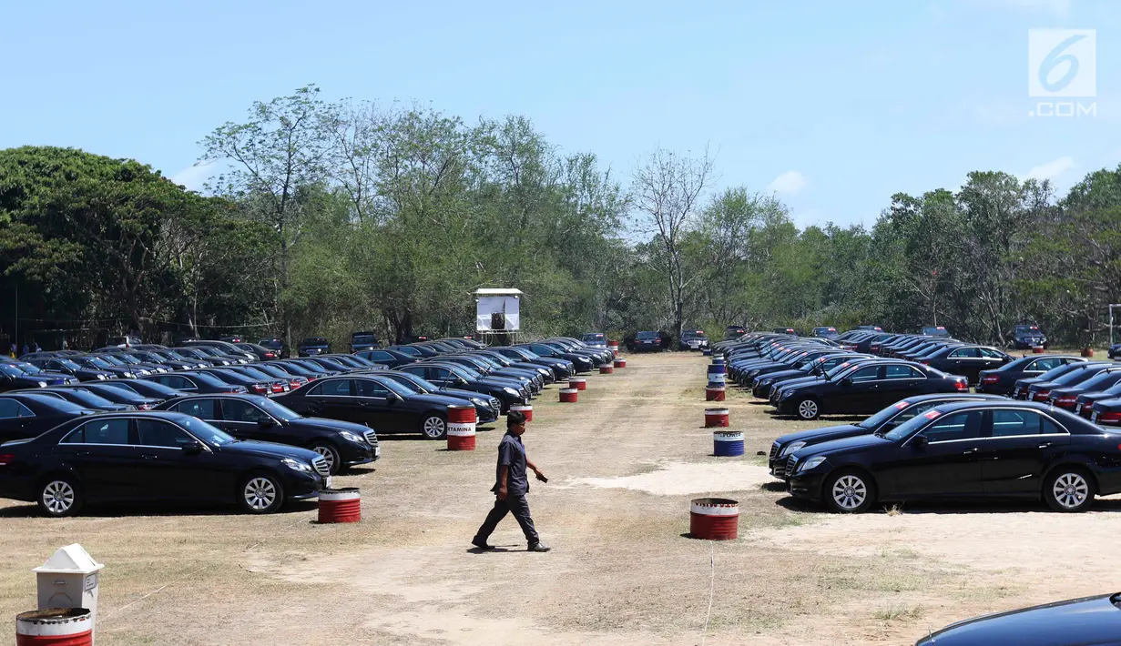 Seorang supir berjalan di antara mobil Toyota Camry dan Mercy E200 di Lapangan Lagoon Bali, Nusa Dua, Selasa (9/10). Sebanyak 865 unit kendaraan disiapkan untuk mengangkut delegasi Pertemuan Tahunan IMF-World Bank di Bali. (Liputan6.com/Angga Yuniar)