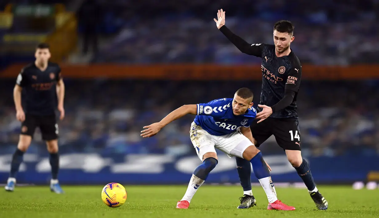 Pemain Manchester City Aymeric Laporte (kanan) memperebutkan bola dengan pemain Everton Richarlison pada pertandingan Liga Inggris di Stadion Goodison Park, Liverpool, Inggris, Rabu (17/2/2021). Manchester City menang 3-1. (Michael Regan/Pool via AP)