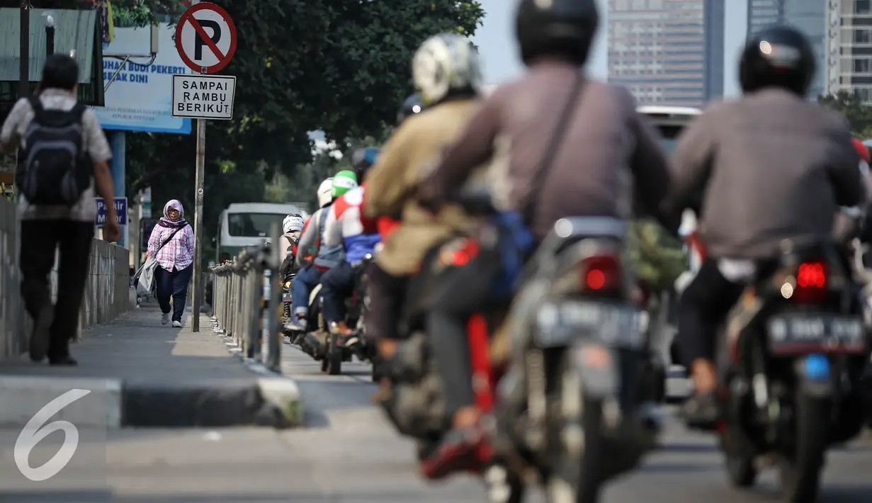 Seorang pejalan kaki melintas melalui trotoar dikawasan Sudirman, Jakarta, Senin (18/4). Gubernur Basuki T Purnama berencana memperlebar trotoar sampai 9,5 meter agar mempermudah orang berjalan kaki usai naik kereta atau bus. (Liputan6.com/Faizal Fanani)