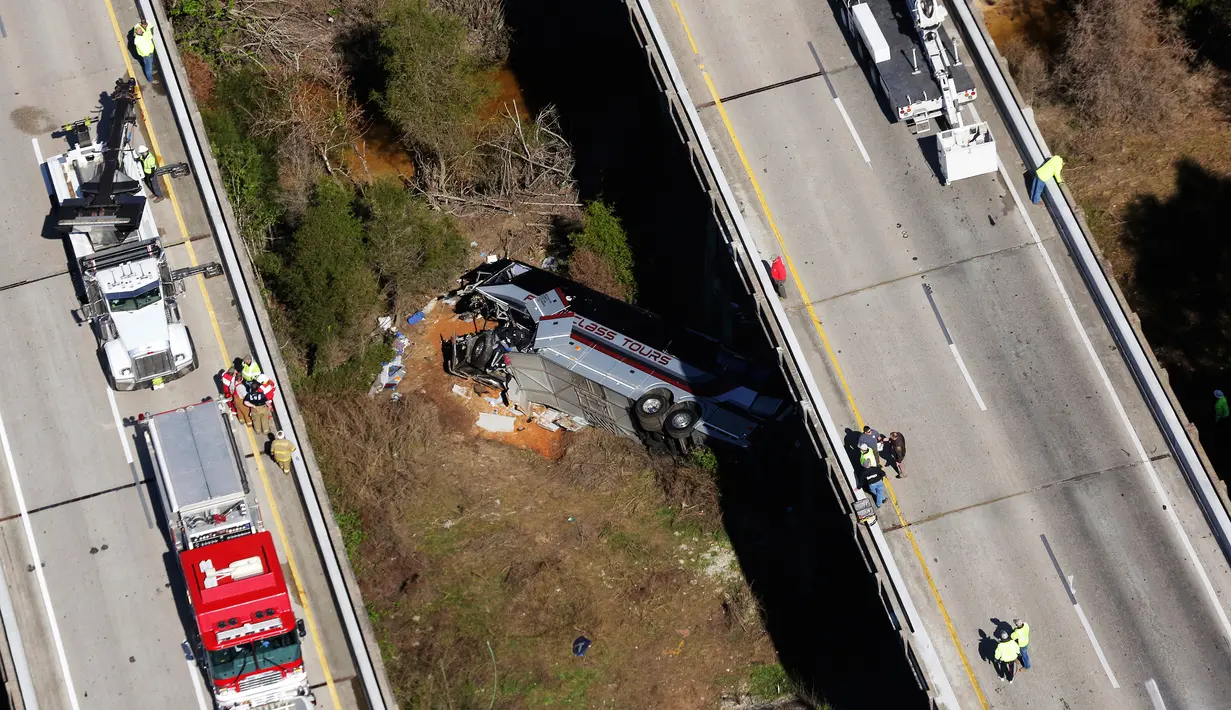 Petugas penyelamat mengevakuasi bangkai bus carteran yang kecelakaan di Loxley, Alabama (13/3). Dilaporkan sopir dari bus ini meninggal, dan puluhan penumpang mengalami luka berat. (AP Photo / Dan Anderson)
