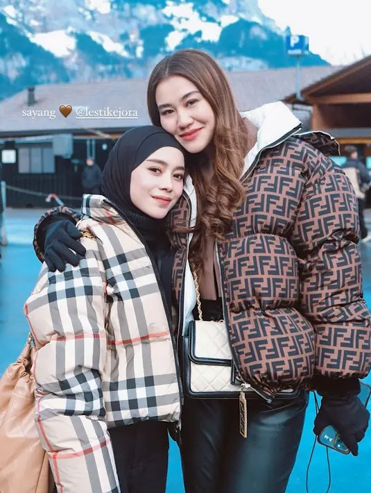 Lesti juga tampil dengan jaket tebal motif kotak-kotak sambil membawa tas Chanel coklat. Dipadukan inner halter neck dan kerudung hitam. [@aaliyah.massaid]