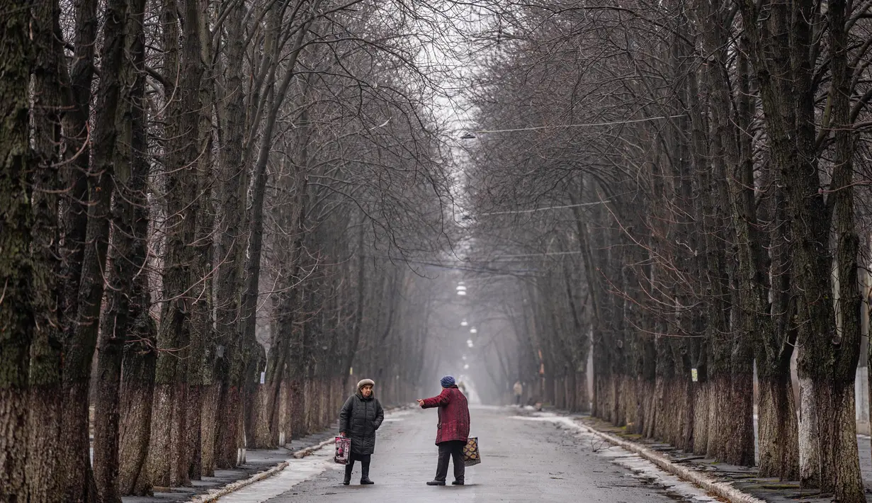 Foto 1: Warga setempat berbincang di sebuah jalan di Chasiv Yar, dekat Bakhmut pada 28 Februari 2023. Pihak berwenang Ukraina mengatakan pada 28 Februari, pasukannya berada di bawah tekanan di Bakhmut, sebuah kota yang hampir hancur di wilayah Donetsk timur yang telah berusaha direbut Rusia selama berbulan-bulan. (Dimitar DILKOFF/AFP)