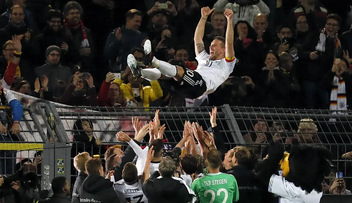 Gelandang Jerman, Lukas Podolski, melakukan selebrasi bersama rekan senegaranya. Di laga terakhirnya bersama Jerman, Podolski, berhasil mencetak gol kemenangan atas Inggris. (EPA/Ronald Wittek)
