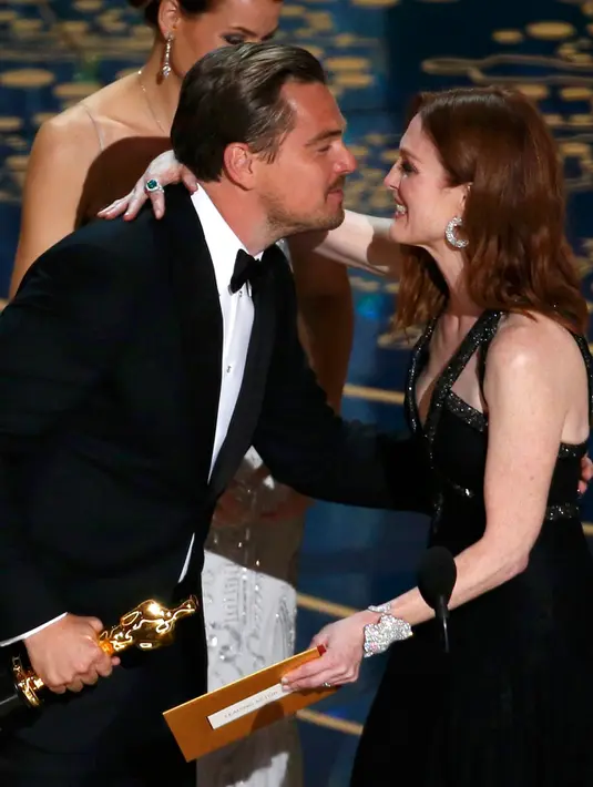 Julianne Moore memberikan selamat kepada aktor Leonardo DiCaprio saat mendapatkan piala oscar untuk Aktor Terbaik untuk film "The Revenant" dari Julianne Moore di 88 Academy Awards di Hollywood, California 28 Februari 2016. (REUTERS/Mario Anzuoni)