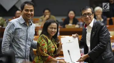 Menkumham Yasonna Laoly (kanan) menunjukkan dokumen saat rapat pleno terkait amnesti untuk Baiq Nuril dengan Komisi III DPR di Gedung Nusantara II, Jakarta, (24/7/2019). DPR setuju Presiden Joko Widodo atau Jokowi memberikan amnesti kepada Baiq Nuril. (Liputan6.com/JohanTallo)