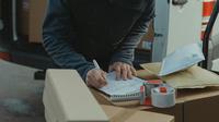 Seorang kurir sedang memeriksa sura jalan (Credit: Pexels)