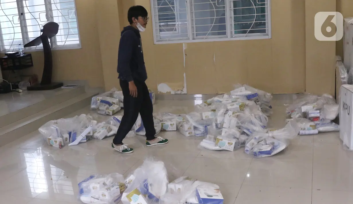 Kesibukan pendistribusian alat pelindung diri (APD) untuk setiap TPS di Parigi, Tangerang Selatan, Selasa (8/12/2020). Panitia Pemungutan Suara (PPS) menyiapkan APD seperti masker, sarung tangan, baju hazmat, ember pencuci tangan untuk keperluan Pilkada Tangsel. (Liputan6.com/Angga Yuniar)