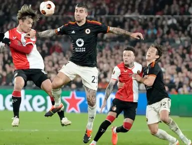 Pemain Feyenoord, Ayase Ueda (kiri) berebut bola atas dengan Gianluca Mancini (AS Roma) selama pertandingan sepak bola leg pertama play off Liga Europa 2023/2024 di Stadion De Kuip, Rotterdam, Belanda, Kamis, 15 Februari 2024. (AP Photo/Peter Dejong)