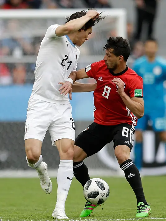 Penyerang Uruguay Edinson Cavani berebut bola dengan pemain Mesir Tarek Hamed saat bertanding pada grup A Piala Dunia 2018 di Yekaterinburg Arena, Rusia, (15/6). Uruguay menang dramatis atas Mesir 1-0. (AP Photo / Natacha Pisarenko)