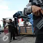 Petugas berjaga dibelakang truk penyelundupan barang asal impor melalui jalur interseluler di Polres Pelabuhan Tanjung Priok, Jakarta, Senin (23/11). Polres Pelabuhan berhasil mengamankan 298 koli muatan dari KM UMSINI. (Liputan6.com/Immanuel Antonius)