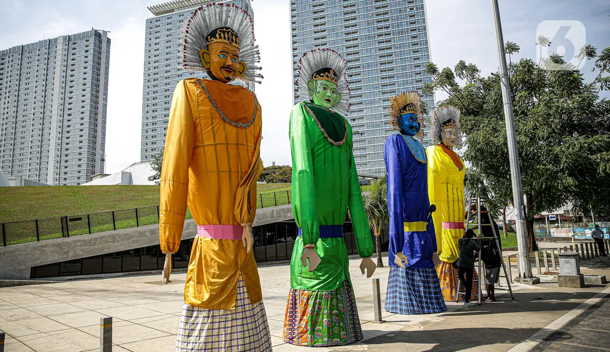 Sejumlah pekerja merapikan ondel-ondel yang dipasang di Taman Ismail Marzuki (TIM), Jakarta, Selasa (22/6/2021). Sebanyak 10 ondel-ondel raksasa setinggi 4,94 meter akan dipamerkan di TIM saat peringatan HUT ke-494 DKI Jakarta yang berlangsung dari 22 hingga 30 Juni 2021 (Liputan6.com/Faizal Fanani)