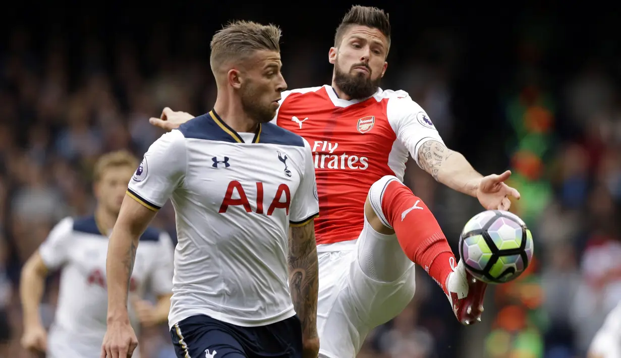 Striker Arsenal, Olivier Giroud, berusaha melewati bek Tottenham, Toby Alderweireld, pada laga Premier League di Stadion Emirates, London, Sabtu (18/11/2017). Arsenal menang 2-0 atas Tottenham. (AP/Alastair Grant)