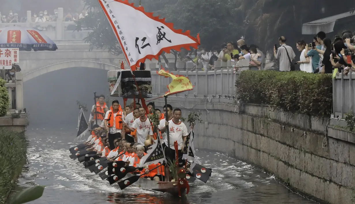 <p>Peserta perahu naga dari desa Panting mendayung di sepanjang kanal di kawasan bersejarah Teluk Lychee di Guangzhou di Provinsi Guangdong, Tiongkok selatan, Jumat, 3 Juni 2022. Perlombaan perahu naga kembali digelar di beberapa bagian China untuk pertama kalinya sejak merebaknya pandemi pada akhir 2019, saat pembatasan dicabut bersama dengan penurunan besar kasus COVID-19. (AP Photo/Caroline Chen)</p>