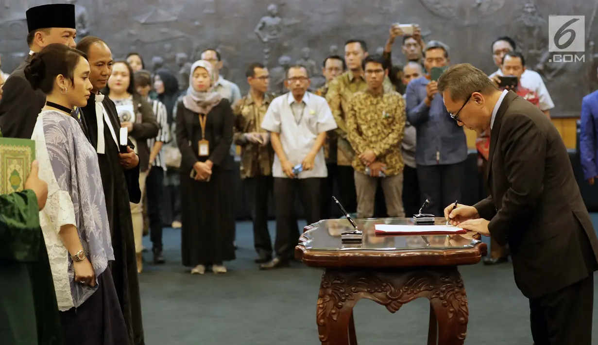Ketua MPR Zulkifli Hasan menandatangani dokumen selama sumpah jabatan anggota MPR Pengganti Antar Waktu (PAW) di Kompleks Parlemen, Senayan, Jakarta, Kamis (18/10). MPR melantik sembilan orang anggota dewan dalam PAW tersebut. (Liputan6.com/Johan Tallo)