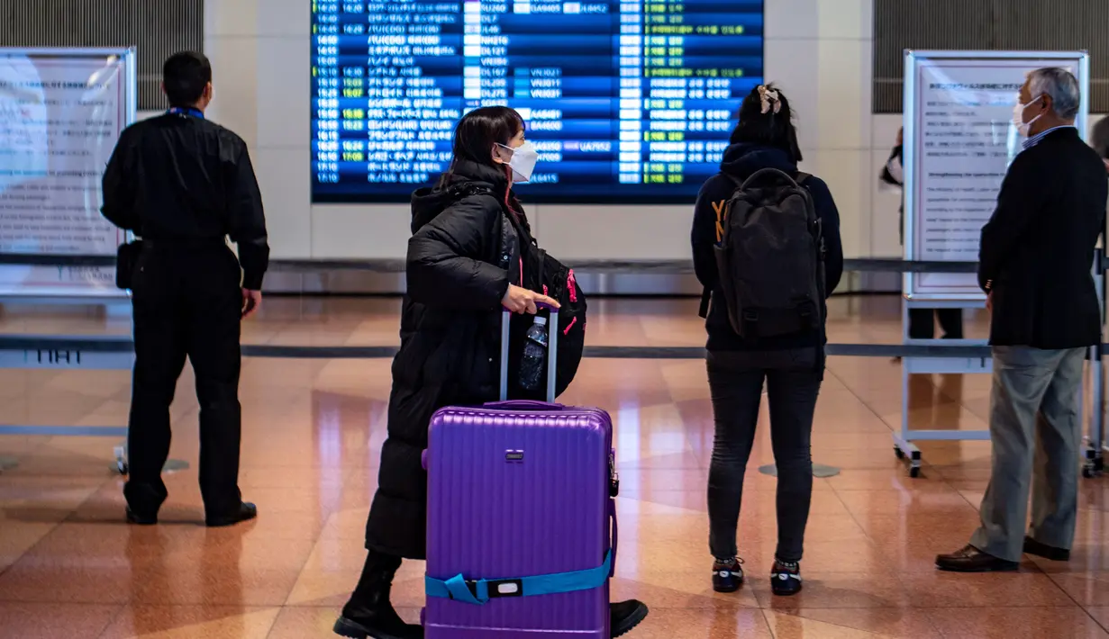 <p>Penumpang berjalan melalui aula kedatangan di Bandara Internasional Haneda Tokyo, Jumat (18/2/2022). Pemerintah Jepang mengumumkan rencana untuk melonggarkan aturan perbatasan virus bagi pekerja dan pelajar. (AFP/Philip Fong)</p>
