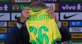 Pelatih kepala tim nasional sepak bola Brasil yang baru, Carlo Ancelotti memegang jersey tim nasional yang diterimanya saat memberi keterangan terkait nama-nama pemain yang akan bertanding di kualifikasi Piala Dunia melawan Ekuador dan Paraguay, di Rio de Janeiro, Senin 26 Mei 2025. (AP Photo/Silvia Izquierdo)
