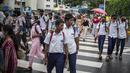Pejalan kaki yang mengenakan masker berjalan melalui zebra cross di Kochi, negara bagian Kerala, India, Rabu (6/7/2022). Negara bagian selatan itu telah mewajibkan penggunaan masker di tempat-tempat umum menyusul meningkatnya kasus COVID-19. (AP Photo/ RS Iyer)