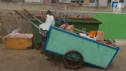 Pemulung mengambil sampah di tong sampah asal Jerman di kawasan Kampung Pulo, Jakarta, Selasa (5/6). Tong sampah asal Jerman tersebut berkapasitas 660 liter dengan total anggaran Rp 9,6 miliar untuk 2.600 tempat sampah. (Merdeka.com/Imam Buhori)