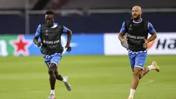 Pemain Getafe, Djene Dakonam dan David Timor melakukan pemanasan saat sesi latihan di Veltins-Arena di Gelsenkirchen, Jerman, Selasa, (4/8/2020). Getafe akan bertanding melawan Inter Milan pada babak 16 besar Liga Europa di Veltins Arena. (Lars Baron / Pool via AP)