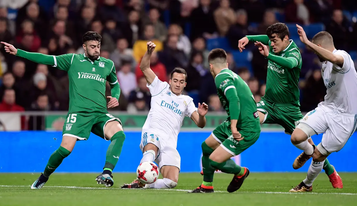 Gelandang Real Madrid, Lucas Vazquez berebut bola dengan pemain Leganes, Diego Rico pada leg kedua perempatfinal Copa del Rey di Santiago Bernabeu, Kamis (25/1). Real Madrid tersisih oleh Leganes pada perempat final dengan skor 1-2. (JAVIER SORIANO/AFP)