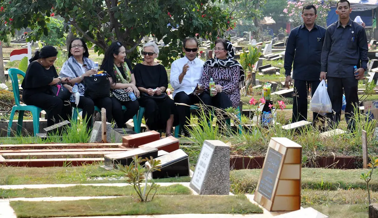 Usai pelayat pulang, Budi Mulya dan keluarga masih menghabiskan waktu dengan duduk di bawah pohon menggunakan kursi plastik, Jakarta, Senin (8/9/14). (Liputan6.com/Miftahul Hayat)