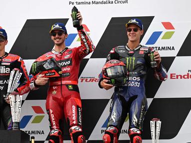 Pembalap Ducati Lenovo Team, Francesco Bagnaia (tengah), bersama pembalap Aprilia Racing, Maverick Vinales (kiri) dan pembalap Monster Energy Yamaha, Fabio Quartararo, berhasil meraih podium juara MotoGP Mandalika 2023 setelah menjalani balapan di Mandalika International Street Circuit, Lombok, Minggu (15/10/2023) siang WIB. (AFP/Sonny Tumbelaka)