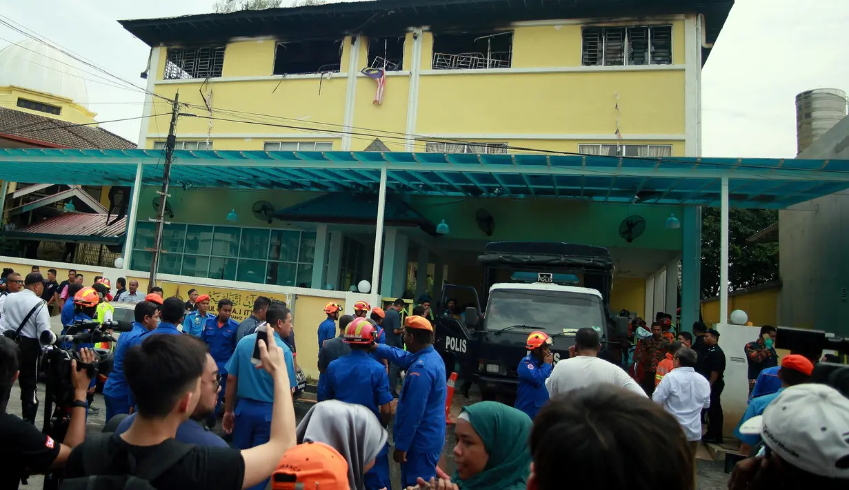 Petugas Pemadam Kebakaran dan Penyelamatan Malaysia berdiri di luar sekolah agama Darul Quran Ittifaqiyah di Kuala Lumpur, Malaysia (14/9). Akibat kebakaran ini 25 orang meninggal dunia. (AFP Photo/Sadiq Asyraf)