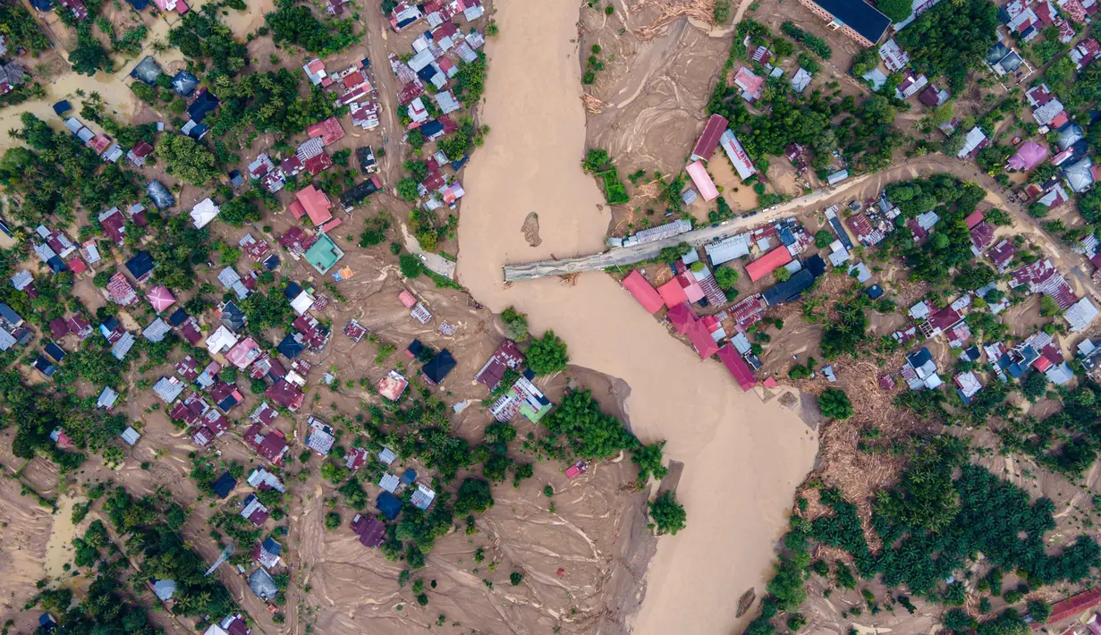 Foto udara menunjukkan jembatan yang rusak akibat banjir bandang di jalan utama yang menghubungkan Aceh dan Sumatera Utara di Meureudu, Kabupaten Pidie Jaya, Provinsi Aceh, pada Jumat 28 November 2025. Derasnya terjangan arus air yang melanda kawasan Kabupaten Pidie Jaya membuat Jembatan Meureudu yang menghubungkan Banda Aceh dan Medan putus total. (CHAIDEER MAHYUDDIN/AFP)