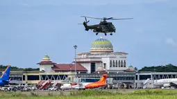 Pesawat dan helikopter dikerahkan secara intensif untuk distribusi logistik dan evakuasi, terutama ke daerah yang akses daratnya terputus. Tampak dalam foto, sebuah helikopter kembali ke pangkalan setelah mengirimkan bantuan kepada korban banjir, di Pangkalan Tentara Nasional Indonesia (TNI) Angkatan Udara (AU) di Blang Bintang, Provinsi Aceh, pada Minggu 7 Desember 2025. (Chaideer MAHYUDDIN/AFP)