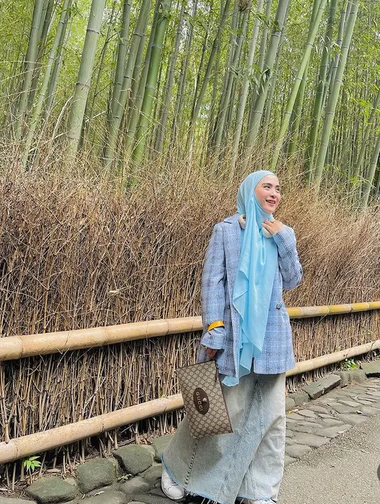April juga tampil dengan kerudung biru dipadukan blazer oversize dan rok denim, sambil membawa clutch Gucci. [@apriljasmine]