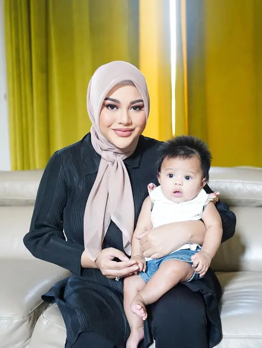 Berpose bersama sang anak, Aurelie Hermansyah tampil cantik. Dengan nuansa makeup natural berwarna merah muda yang hangat, dipadu kontras dengan outfit berwarna hitamnya. Foto: Instagram.