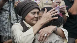 Seorang anggota Kwarnas Gerakan Pramuka memeluk ibunya dalam kegiatan "Membasuh Kaki Ibu" secara massal  di Taman Wiladatika Cibubur, Jakarta, Rabu (21/12). Aksi massal membasuh kaki ibu itu untuk memperingati Hari Ibu 2016. (Liputan6.com/Yoppy Renato)
