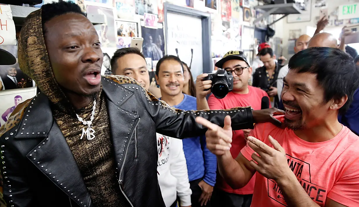 Petinju Manny Pacquiao (kanan) bercanda dengan komedian Michael Blackson saat berlatih di sebuah klub tinju di Los Angeles, AS, Rabu (9/1). Pacquiao satu-satunya petinju yang mampu menjadi juara tinju dunia di 8 kelas berbeda. (AP Photo/Damian Dovarganes)