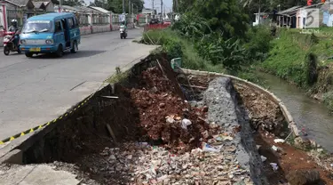 Kendaraan melintas di samping Jalan Raya Citayam yang amblas di kawasan Cipayung, Depok, Jawa Barat, Rabu (27/2). Kondisi tepi jalan yang tidak kunjung diperbaiki membahayakan pengguna jalan terutama saat malam hari. (Liputan6.com/Immanuel Antonius)