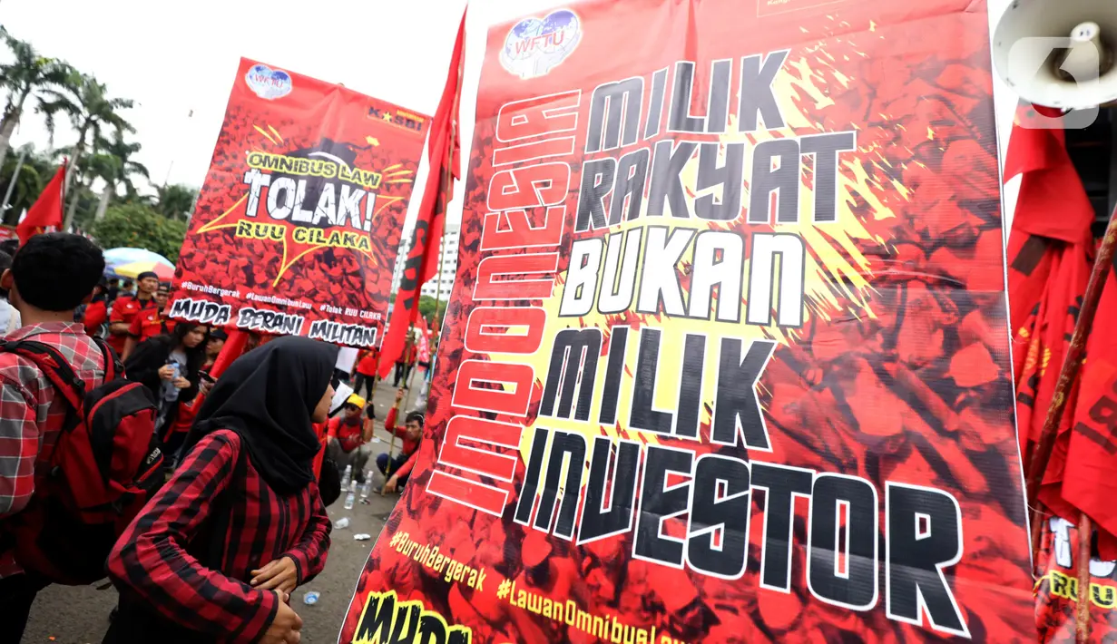 Poster bertuliskan tuntutan terlihat saat buruh yang tergabung dalam Gerakan Buruh Bersama Rakyat (Gebrak) berdemonstrasi di depan Gedung DPR, Jakarta, Senin (13/1/2020). Massa menyuarakan penolakan mereka terhadap Omnibus Law Rancangan Undang-Undang Cipta Lapangan Kerja. (Liputan6.con/Johan Tallo)