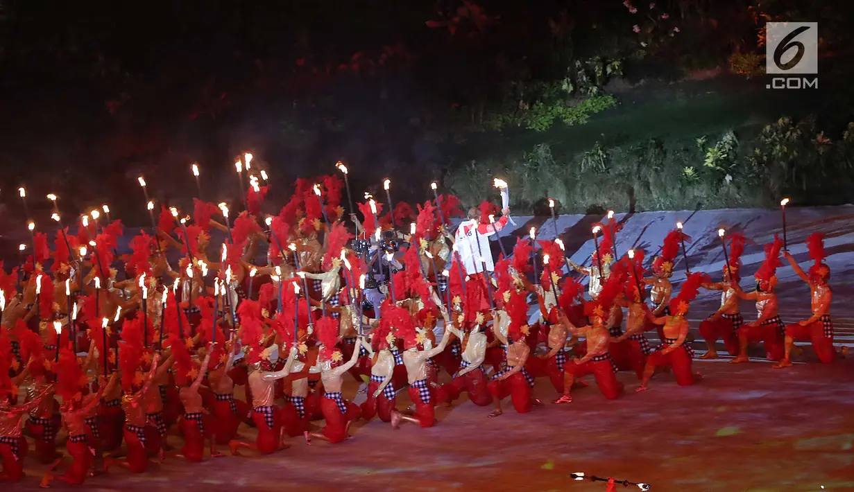 Peraih dua medali emas Asian Games 1978 dan dua medali emas Asian Games 1982 Yustedjo Tarik membawa obor Asian Games 2018 saat pembukaan di Stadion Utama Gelora Bung Karno (SUGBK), Jakarta, Sabtu (18/8). (Liputan.com/Fery Pradolo)