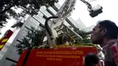 Petugas pemadam kebakaran dan teknisi konstruksi mengevakuasi pelapis dinding gedung Sekretariat Jenderal DPR RI yang roboh ditiup angin kencang di Kompleks Parlemen, Jakarta, Jumat (24/04/2015). (Liputan6.com/Andrian M Tunay)